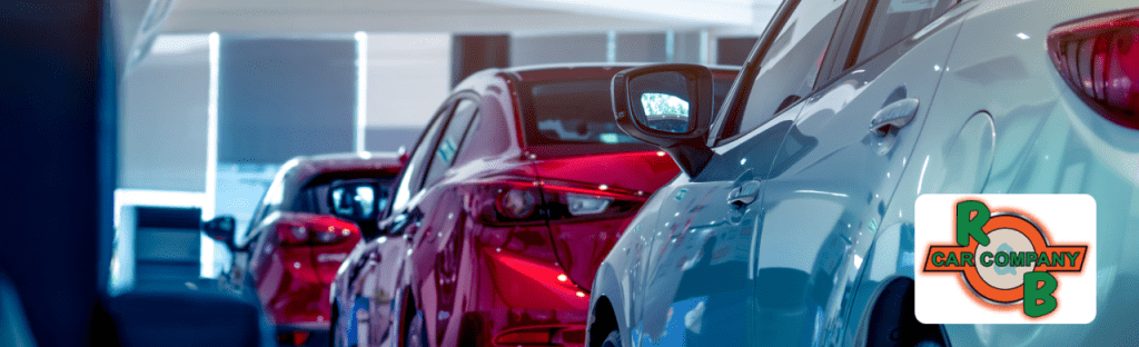 A row of used and new vehicles displayed at R&B Car Company South Bend dealership lot under bright sunshine.